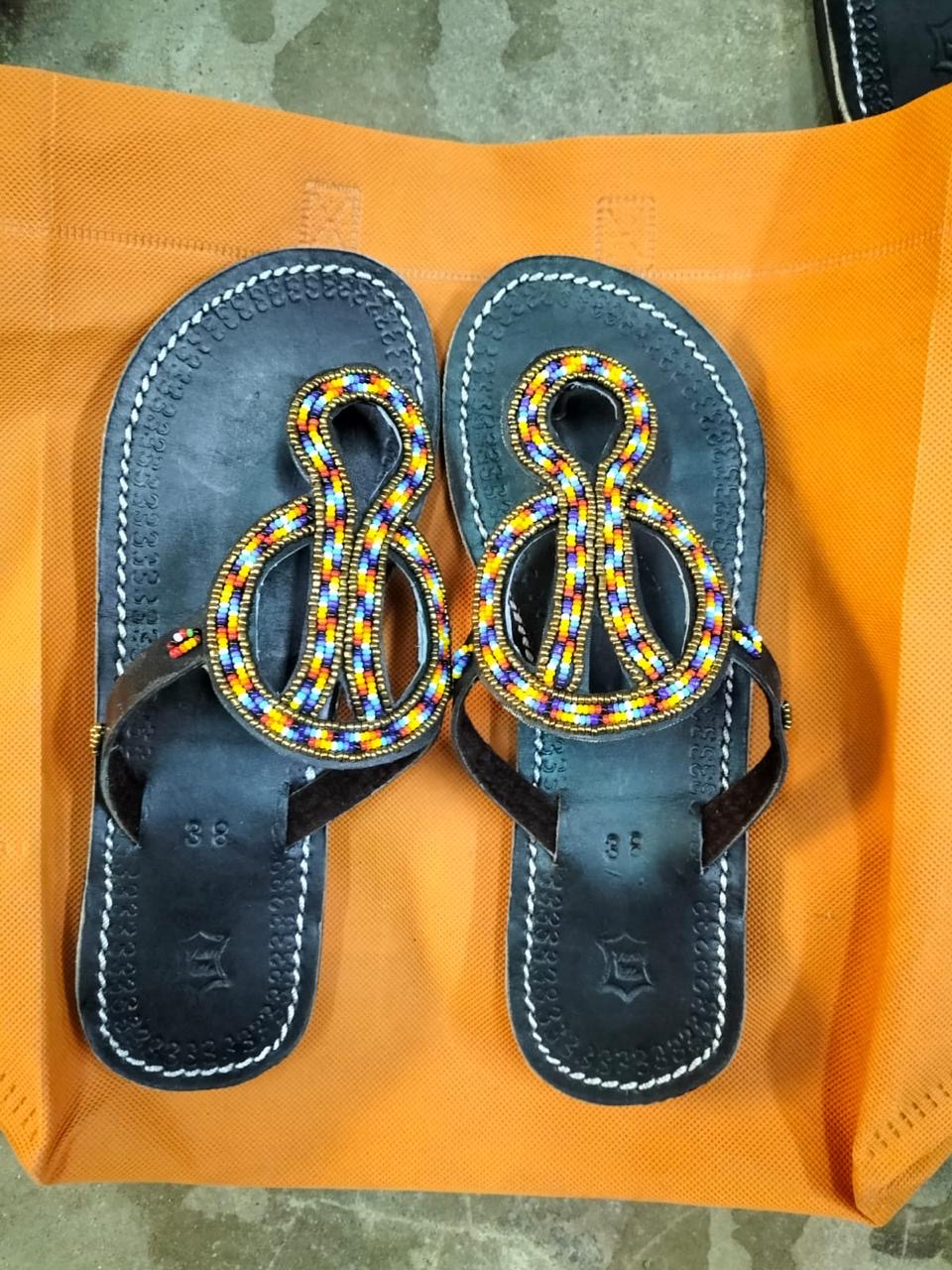 Beaded Leather Sandals by Caroline Mami Walter — Hand-stitched leather footwear finished with Maasai-inspired glass beadwork.