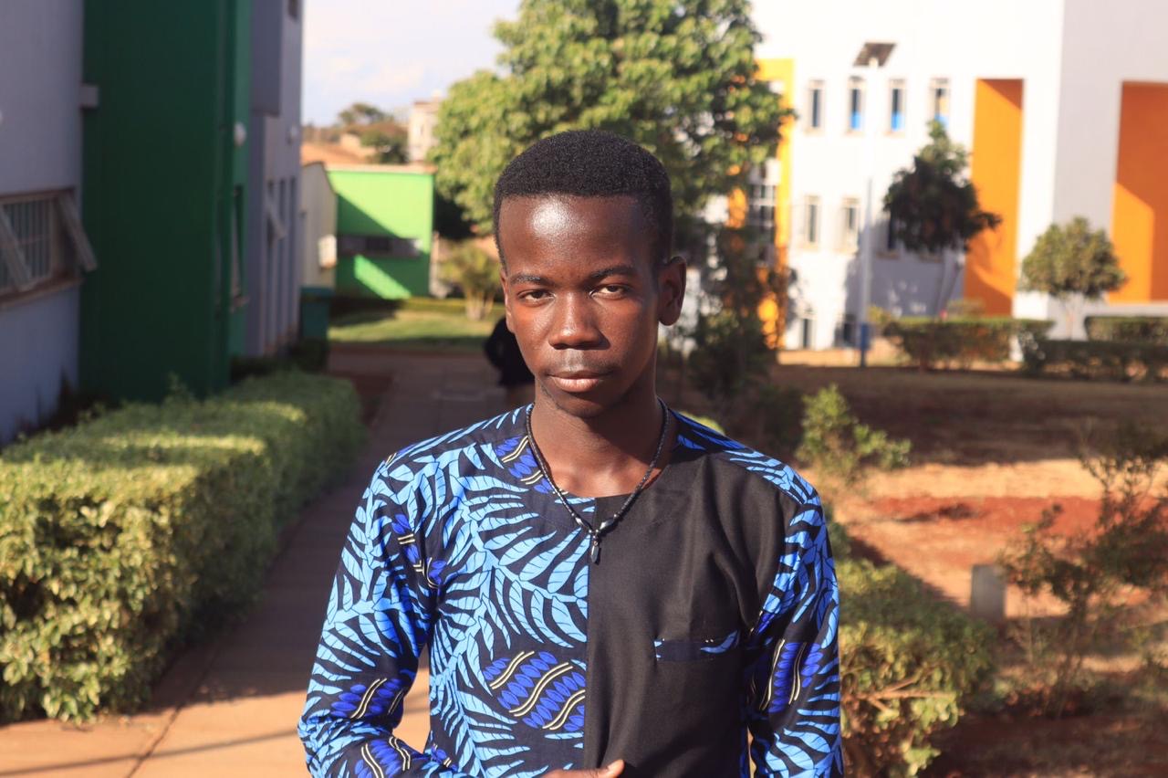 Blue Leaf-Print Panelled Shirt — A collarless shirt splitting plain black against a blue leaf-print kitenge panel.